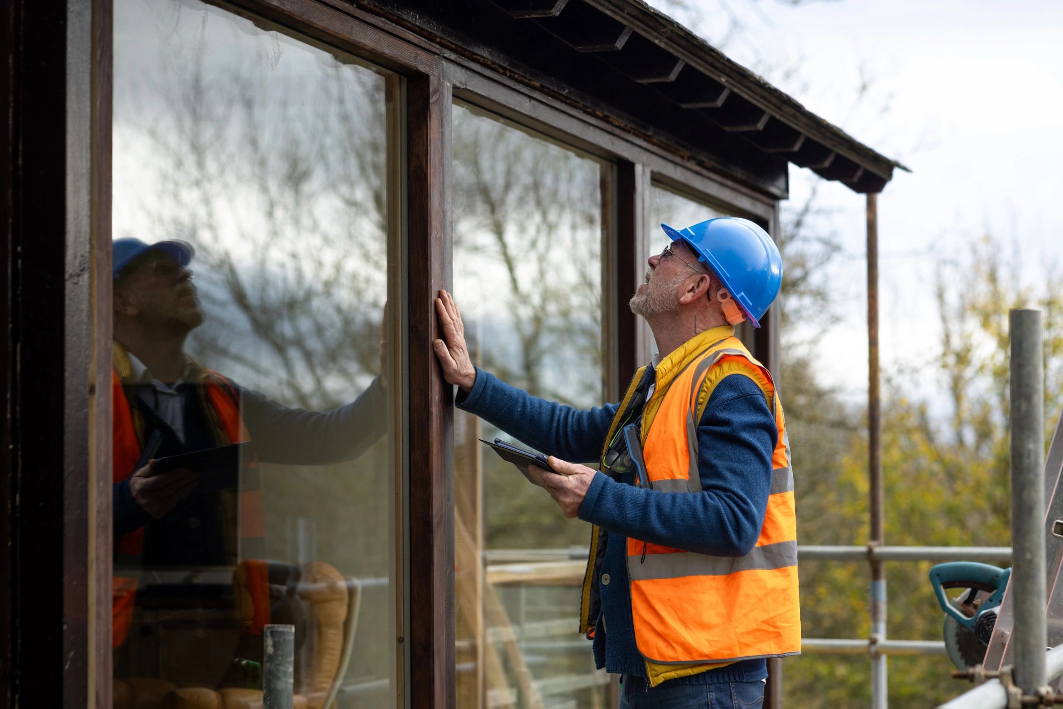 Technician inspecting an exterior area as part of a wildlife removal assessment